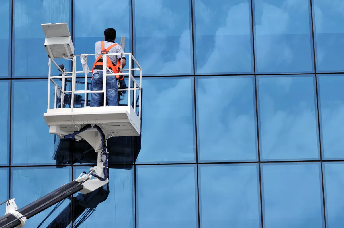 Lavage de vitres en hauteur sur une façade de verre